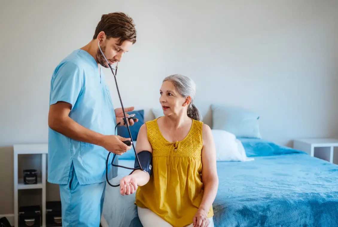 Nurse checking woman's blood pressure at home.