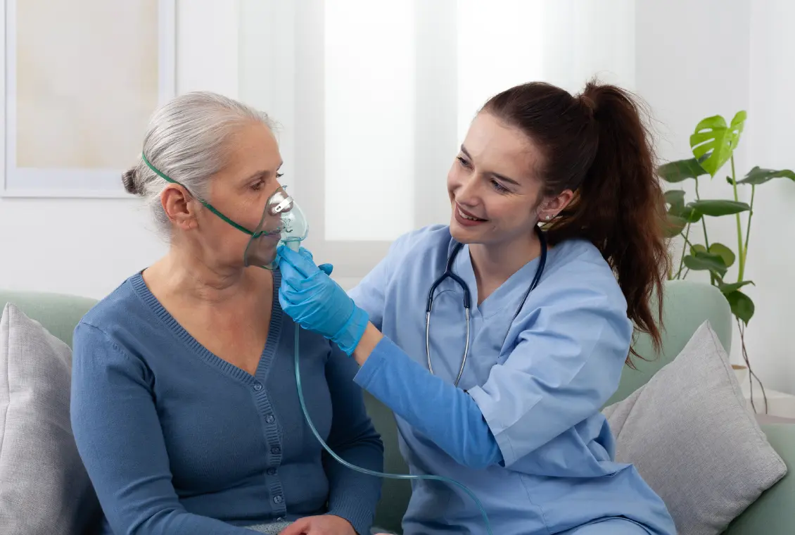 Nurse assisting elderly woman with oxygen mask.