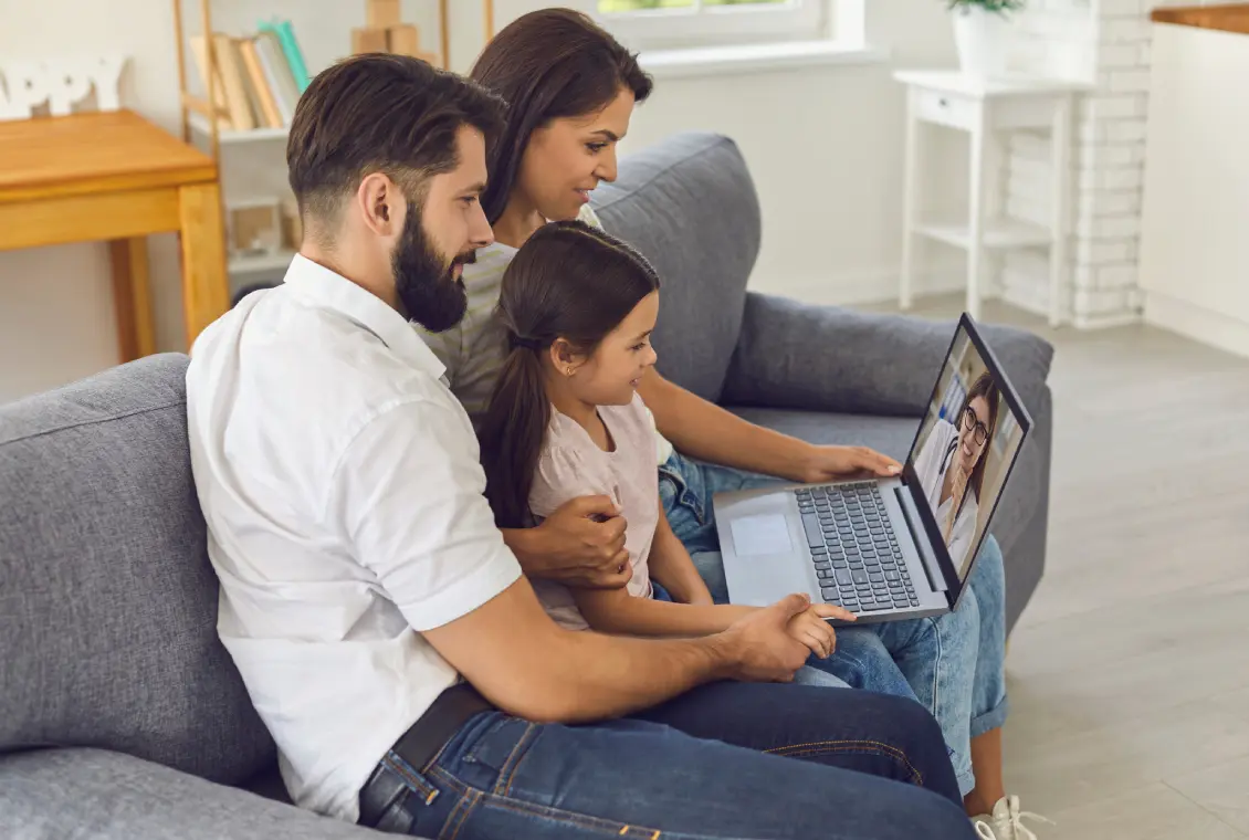 Family video chatting on a laptop together.