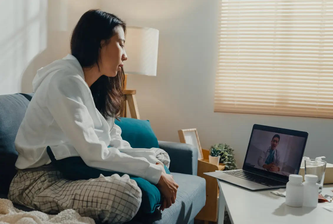 Woman video calling on laptop at home.