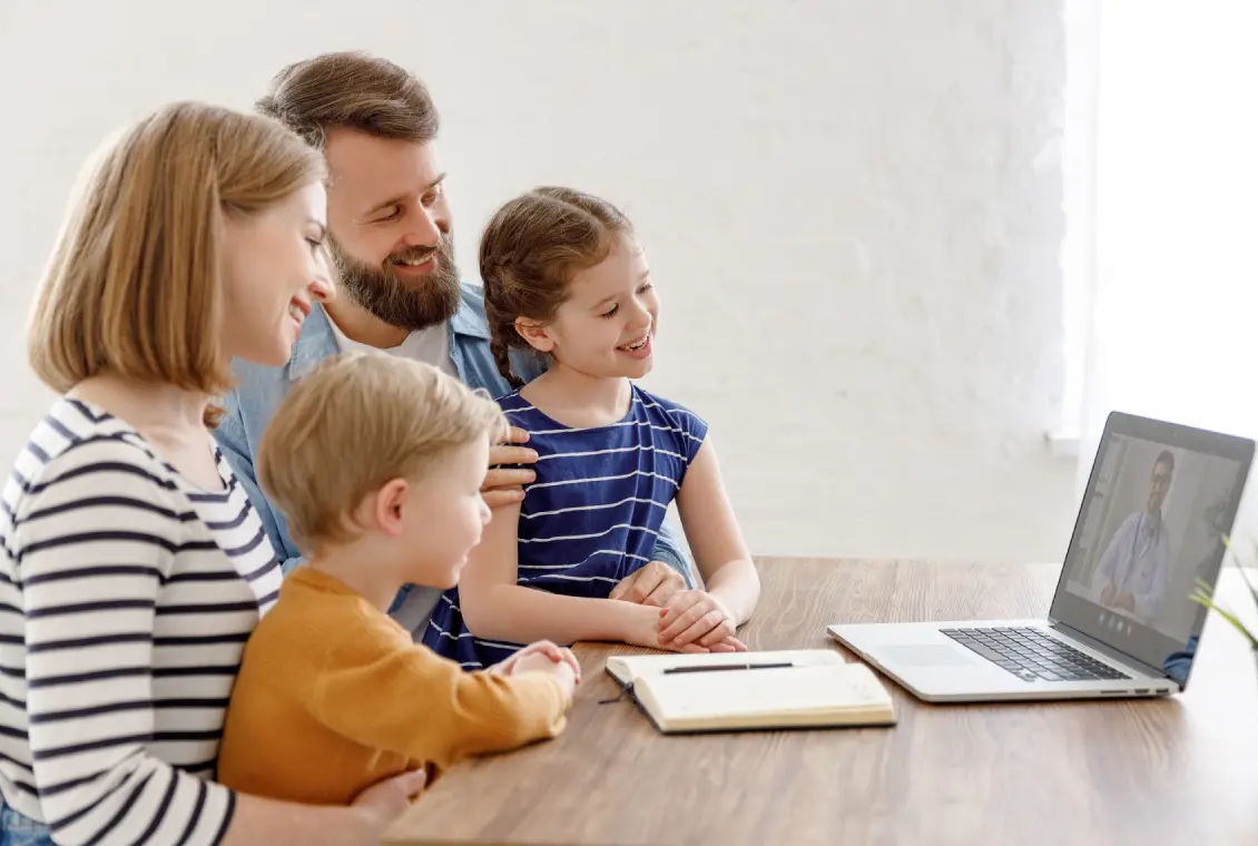 Family video chatting on laptop at home.