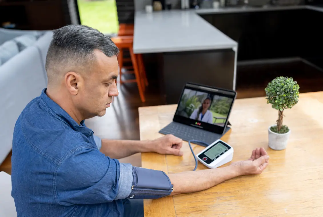Man taking blood pressure during video call.